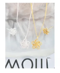 Macro shot of S925 sterling silver hollow flower jewelry set with beaded texture