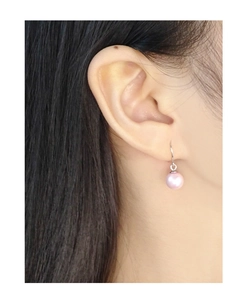 Close-up of a pink pearl drop earring on model ear with S925 silver hook and soft luster