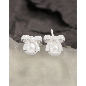 Elegant S925 silver bow stud earrings with white pearls on a grey stone display