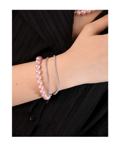 Détail d'un ensemble de bracelets en perles roses et cristaux argentés sur poignet