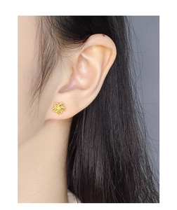 Close-up of a model wearing the gold double-layered hollow flower stud earrings