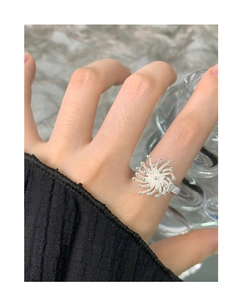 Detailed close-up of a silver firework-shaped open ring worn on a finger