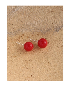 Makro-Detail von 10mm roten Achat-Ohrsteckern mit S925 Sterlingsilber auf Holzboden