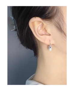 Detail of elegant S925 sterling silver drop earrings with natural white pearls on model