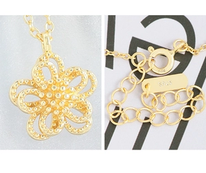 Macro detail of S925 sterling silver hollow flower pendant and spring clasp with hallmark