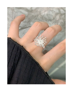 Macro detail of a 925 silver firework-shaped open ring worn on a model's middle finger