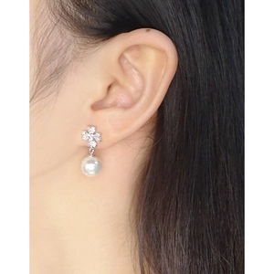 Elegant S925 silver leaf earrings with zircon and white pearl on model's ear