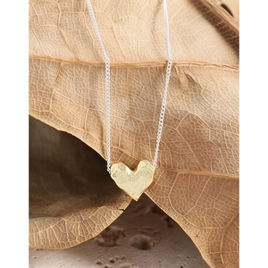 S925 sterling silver heart necklace with golden lava texture on a natural leaf background