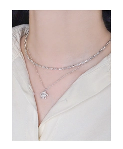 Detail of S925 sterling silver double-layered necklace with hollow flower pendant on neck