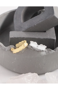 Detailed view of adjustable leaf-patterned rings with zircon inlay in gold and silver