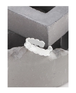 Detail of silver leaf ring with zircon stone on stone background with macro texture