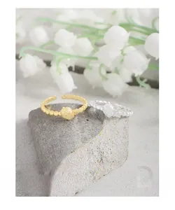 Close-up of strawberry design rings with zircons on a natural stone background