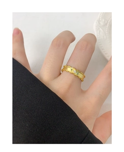 Detail of twisted gold ring band with a sparkling round zircon stone inlay