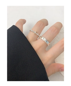 Detailed close-up of S925 sterling silver leaf and star rings on a model's hand