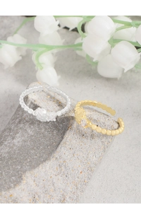 Close-up of S925 sterling silver strawberry rings with cubic zirconia on a stone base