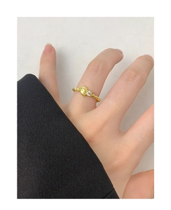 Detail of gold beaded ring featuring a cartoon cat design and sparkling white zircon