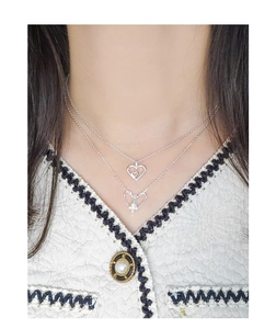 Close-up of double-layer S925 silver heart pendant necklace on model with tweed jacket