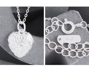 Macro detail of S925 sterling silver heart pendant with floral texture and hallmark
