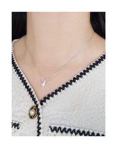 Close-up of S925 sterling silver heart-shaped vase necklace worn by a female model