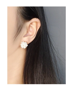 Close-up of cluster pearl stud earrings on model featuring natural freshwater style pearls