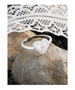 Detailed view of S925 silver heart ring with relief texture and zircon on natural rock