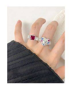 Macro shot of S925 silver rings with square red zircon and multi-color heart pattern