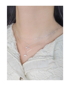Close-up of S925 silver layered necklace with zircon cross and bow arrow pendants