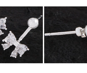 Macro shot of S925 silver stud earrings with bow design and sparkling zircon stones