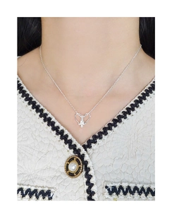 Detail of silver S925 heart pendant necklace on model with white woven clothing