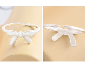 Macro shot of S925 sterling silver bow ring featuring engraved hallmark and adjustable band