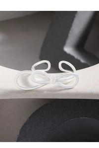 Macro detail of silver double-layered bow ring on textured architectural stone base
