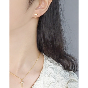 Elegant gold cross jewelry set with zircon studs and necklace on a female model