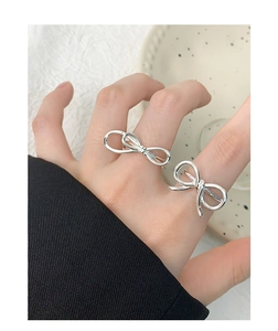 Close-up of S925 sterling silver bow knot rings on hand with minimalist aesthetic