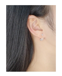 Detail of S925 silver bow stud earrings with zircon stones on a model's ear