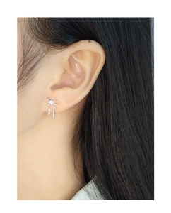 Close-up of S925 sterling silver bow knot ribbon stud earrings worn by a model
