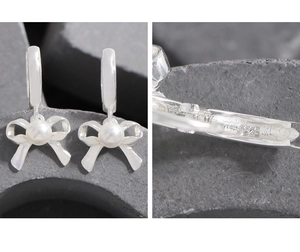 Macro detail of S925 sterling silver stamp on elegant bow and pearl earrings