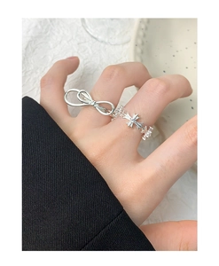 Detail shot of a double-layered bow ring and cross band in S925 sterling silver