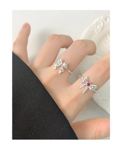 Detail shot of two S925 sterling silver bow rings featuring a pink zircon gemstone inlay