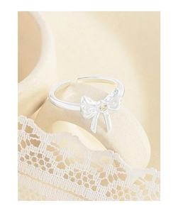 Detail of S925 silver bow ring featuring a sparkling zircon centerpiece on lace fabric