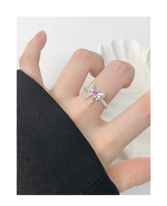Detail of S925 silver bow ring featuring a sparkling pink zircon on a female hand