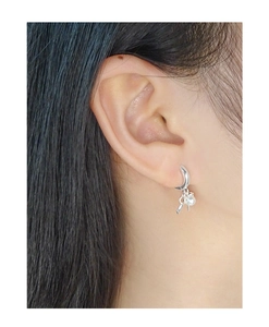 Close-up of elegant crescent moon silver earrings with round white pearls on a model