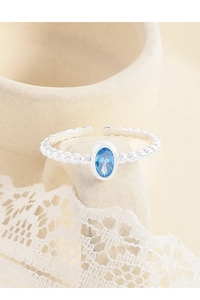 Macro shot of S925 silver ring featuring oval blue zircon on a beaded band detail
