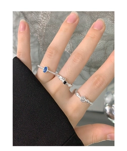 Close-up of S925 sterling silver rings set with blue, black and white oval cubic zirconia