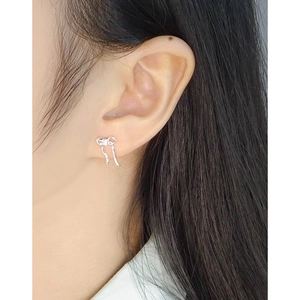 Elegant 925 silver ribbon bow earrings with zircon tassel details on a female model