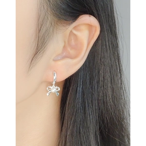 Elegant S925 silver bow pearl earrings on model showing a delicate and minimalist look