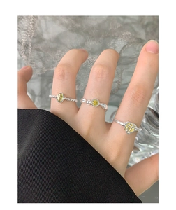 Nahaufnahme von S925 Silberringen mit gelben und olivgrünen Zirkonsteinen an der Hand