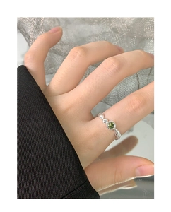 Detailansicht eines silbernen Rings mit grünem Zirkonstein und unregelmäßigem Design