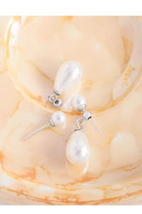Vista macro di orecchini in argento S925 con eleganti perle rotonde e a forma di goccia