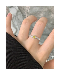 Makroaufnahme eines S925 Silberrings mit gelbem Zirkon am Finger eines Modells