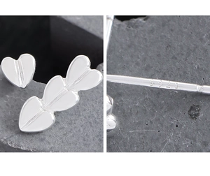 Macro shot of S925 sterling silver heart earrings showing authentic hallmark engraving